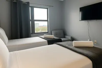 a room with two beds and a tv and a chair at 3704 Relax Unwind 2-BD 2-BA Resort Condo in Orlando