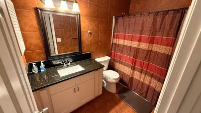 a bathroom with a sink and a toilet and a shower at M13 Large Master Room with Private Bathroom & Smart TV in Orlando