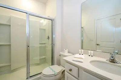 a bathroom with a shower and a toilet and a sink at Stunning Masterpiece 15 ensuites in Kissimmee