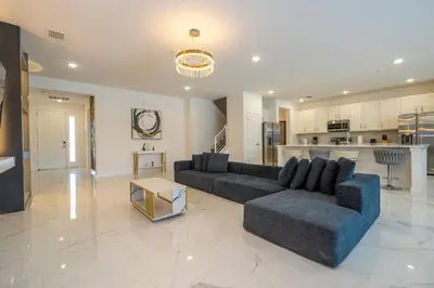 a large living room with a couch and a kitchen at Stunning Masterpiece 15 ensuites in Kissimmee