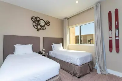 two beds in a room with snowboards on the wall at Modern 4bed townhome in the heart of Kissimmee in Orlando