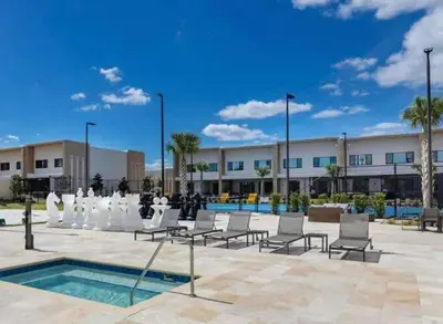 a courtyard with chairs and a pool in front of a building at Modern 4bed townhome in the heart of Kissimmee in Orlando
