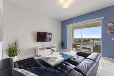 a living room with a couch and a tv at Gorgeous Waterview ,Top Floor, 2Bd Condo, Storey Lake Resort in Kissimmee