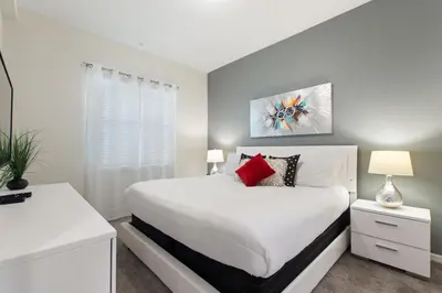 a white bedroom with a white bed and a window at Gorgeous Waterview ,Top Floor, 2Bd Condo, Storey Lake Resort in Kissimmee