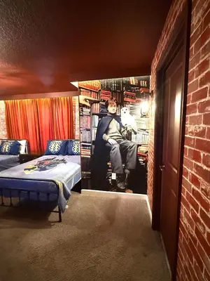 a man sitting in a room with a book shelf at New Themed Rooms5BR Near AttractionsResort in Kissimmee