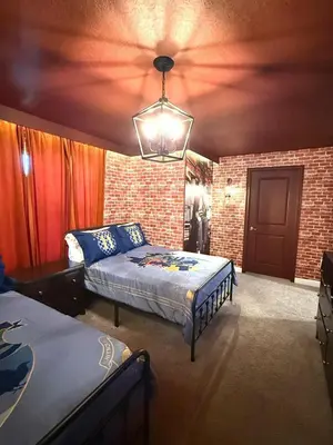 a bedroom with two beds and a brick wall at New Themed Rooms5BR Near AttractionsResort in Kissimmee