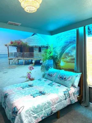 a bedroom with a bed with a painting of the ocean at New Themed Rooms5BR Near AttractionsResort in Kissimmee