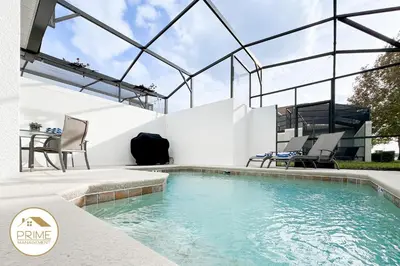 a swimming pool with two chairs and a table at New Themed Rooms5BR Near AttractionsResort in Kissimmee