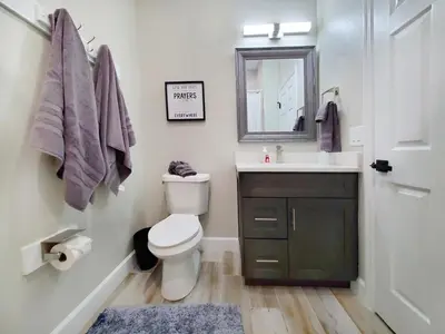 a bathroom with a toilet and a sink and a mirror at Gated 3BR 3BA Townhome Near Disney w Pool and Gym in Orlando