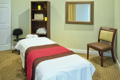 a room with two beds and a mirror and a chair at Wyndham Star Island Resort 2BR Apartment with Resort Access in Kissimmee