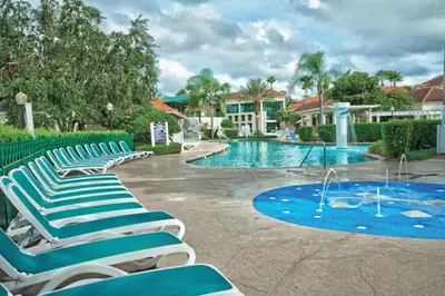a group of lounge chairs next to a swimming pool at Wyndham Star Island Resort 3BR Apartment with Resort Access in Kissimmee