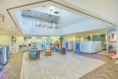 a large lobby with a waiting area and tables and chairs at Wyndham Cypress Palms 1BR Apartment with Resort Access in Kissimmee
