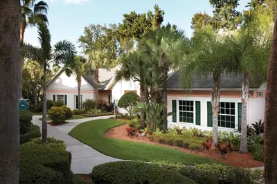 a house with palm trees and a driveway at Wyndham Cypress Palms 1BR Apartment with Resort Access in Kissimmee