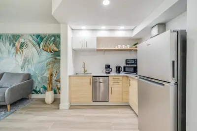 a kitchen with a refrigerator and a couch at Rental near Epic and Universal, free parking in Orlando