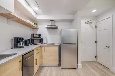 a kitchen with a stainless steel refrigerator and wooden cabinets at Rental near Epic and Universal, free parking in Orlando