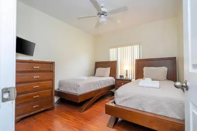 a bedroom with two beds and a ceiling fan at Amazing 6 bedrooms with pool in Kissimmee