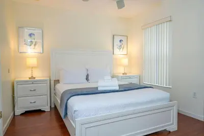 a bedroom with a white bed with two night stands at Amazing 6 bedrooms with pool in Kissimmee