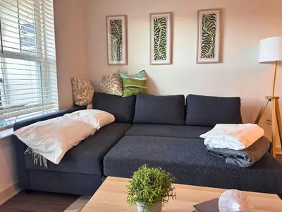 a living room with a blue couch with pillows at Modern Oasis with King Bed, Fireworks View, 10 Minutes to Disney in Orlando