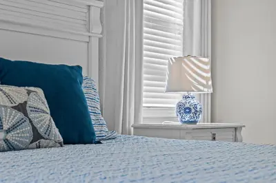 a blue and white bed with a lamp on a table at Family Nest 4-Bedroom Home Near Disney World in Kissimmee