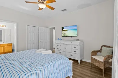 a bedroom with a bed and a dresser and a ceiling fan at Family Nest 4-Bedroom Home Near Disney World in Kissimmee