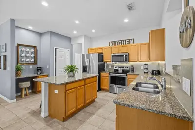 a large kitchen with wooden cabinets and appliances at Family Nest 4-Bedroom Home Near Disney World in Kissimmee