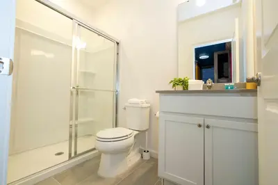 a white bathroom with a toilet and a shower at Paradiso Grande 6 bedroom New Home - 10377 in Orlando