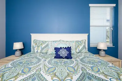 a blue bedroom with a bed with a blue wall at Adventurers Oasis - Private pool in Kissimmee