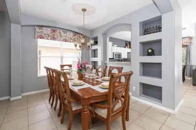 a dining room with a wooden table and chairs at Be Our Guest at Emerald Island in Kissimmee