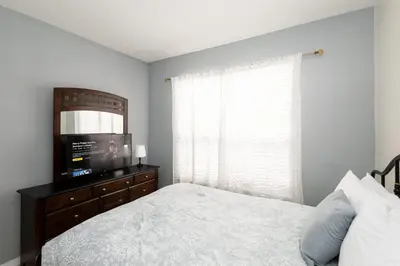 a bedroom with a bed and a flat screen tv at Be Our Guest at Emerald Island in Kissimmee