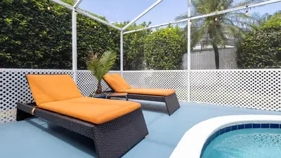 a patio with two chairs and a swimming pool at Beachy Retreat in Orlando