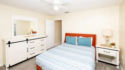 a bedroom with a bed and a ceiling fan at Beachy Retreat in Orlando
