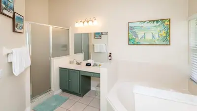 a bathroom with a sink and a shower and a mirror at Beachy Retreat in Orlando