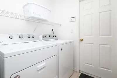 a white kitchen with a stove and a white door at Beachy Retreat in Orlando