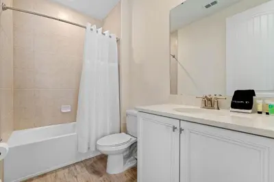 a white bathroom with a toilet and a sink at Capri Sunset in Orlando