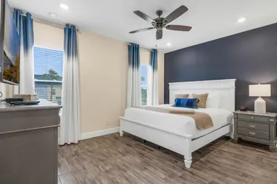 a bedroom with a white bed and a ceiling fan at Caribbean Dreamin - Vibrant Margaritaville Resort in Orlando