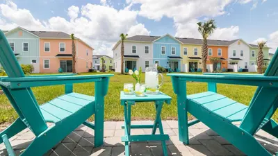 a blue table and chairs on a patio with houses at Caribbean Summer - Serene Patio in Orlando