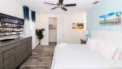 a bedroom with a white bed and a ceiling fan at Caribbean Summer - Serene Patio in Orlando