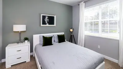 a bedroom with a white bed and a window at Casa de Kissimmee Sleeps up to 13 Guests in Kissimmee