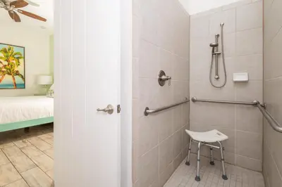 a bathroom with a shower with a chair in it at Coconut Cabana - Access 4 Most in Orlando