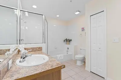 a white bathroom with a sink and a toilet at Cozy Cove - Caribe Escape for 8 in Orlando