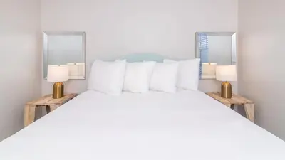 a bedroom with a large white bed with two mirrors at Cozy on Cavendish - Themed bedrooms in Kissimmee