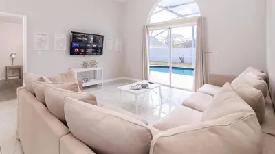 a living room with a couch and a table at Cozy on Cavendish - Themed bedrooms in Kissimmee
