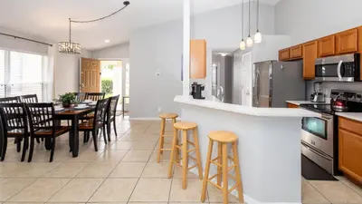 a kitchen and dining room with a table and chairs at Emerald Island Happy Place in Kissimmee