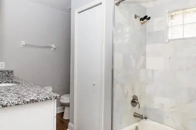 a white bathroom with a shower and a toilet at Wonderland at White Crane - Hot tub & Lake views in Orlando