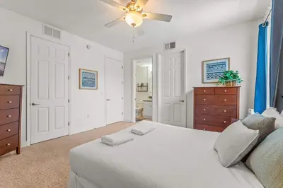 a bedroom with a white bed and a ceiling fan at Family Friendly Relax Villa in Kissimmee