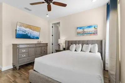 a bedroom with a white bed and a ceiling fan at Flamingo Paradise in Orlando