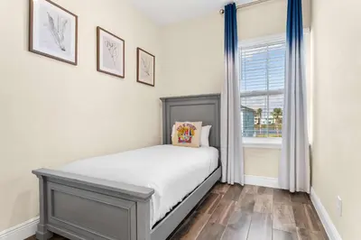 a small bedroom with a bed and a window at Flamingo Paradise in Orlando