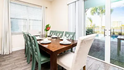 a dining room with a wooden table and chairs at Formosa Mimosa - Margaritaville in Orlando