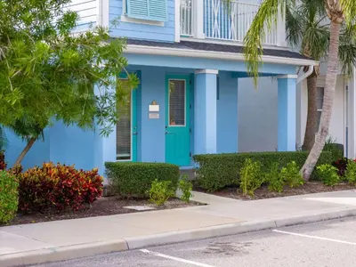 a blue house with a blue door and palm trees at Frankly Fintastic - Happy Days in Orlando