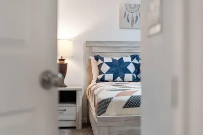 a bedroom with a bed and a table with a lamp at Veranda Sunshine Escape - 5 BDR in Kissimmee